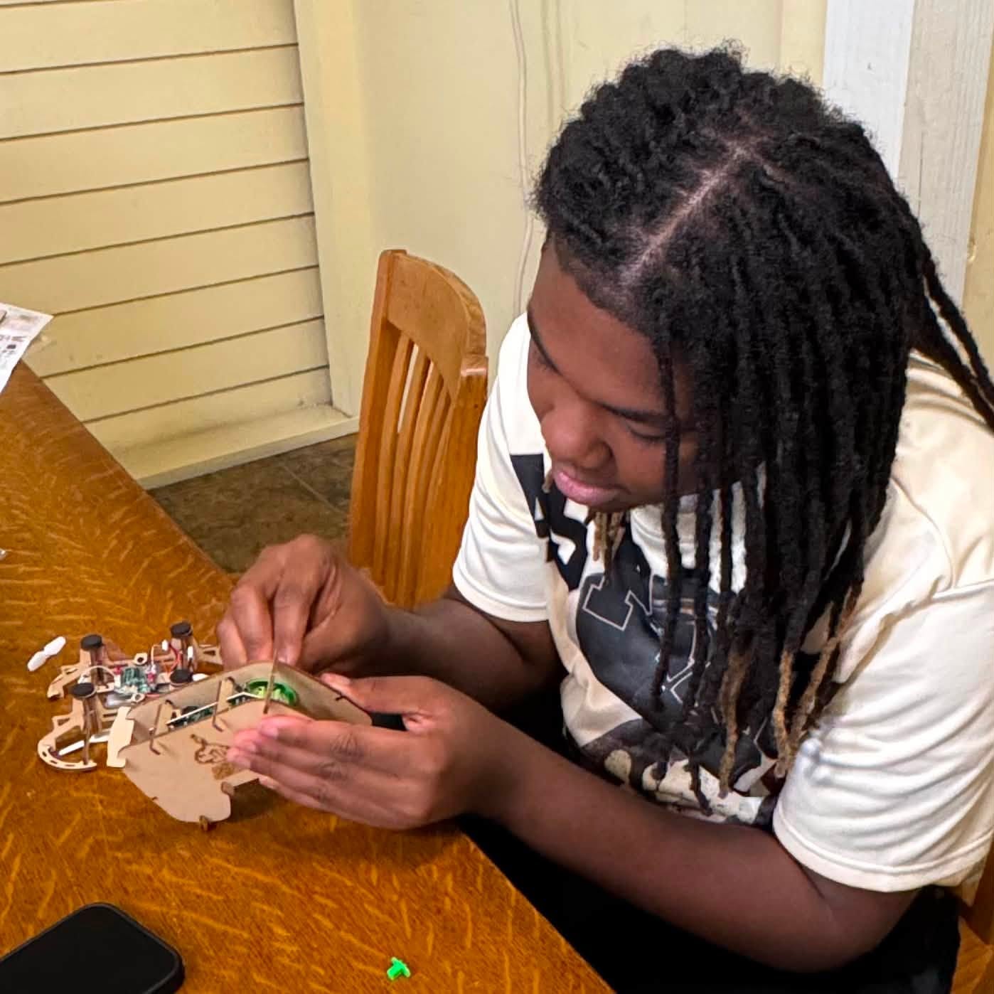 A boy assembling a small drone.